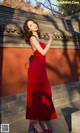 A woman in a red dress holding a fan.