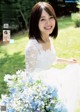 A woman in a wedding dress holding a bouquet of flowers.