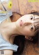 A young woman laying on the floor with a bottle of water in her hand.