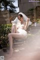 A woman in a wedding dress sitting on a chair.