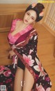 A woman in a kimono sitting on the floor.