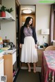 A woman standing in a kitchen next to a table.