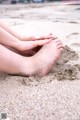 A woman's feet in the sand on a beach.