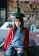 A woman sitting on a table with a lamp on her head.